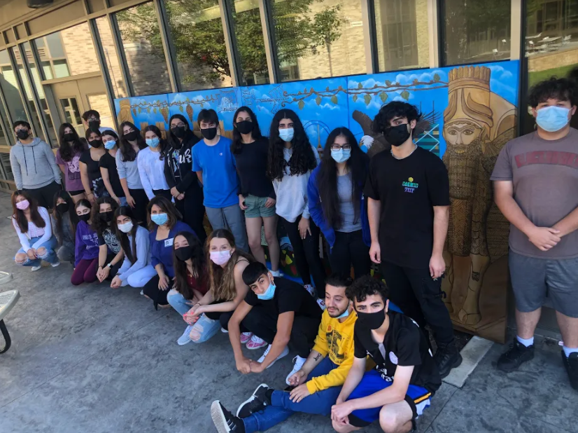 Assyrian Club poses in front of their new mural that is being displayed at Niles North.