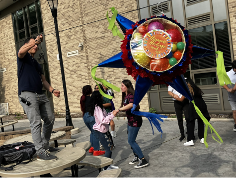 Dean Peña holds the piñata for students. 