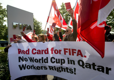 Members of Building and Wood Workers International (BWI) and Swiss Unia unions hold a red cards reading A red card for FIFA, no World Cup without labour rights and a banner reading No World Cup in Qatar Workers Rights! during a demonstration outside the headquarters of the worlds football governing body FIFA in Zurich on October 3, 2013. 