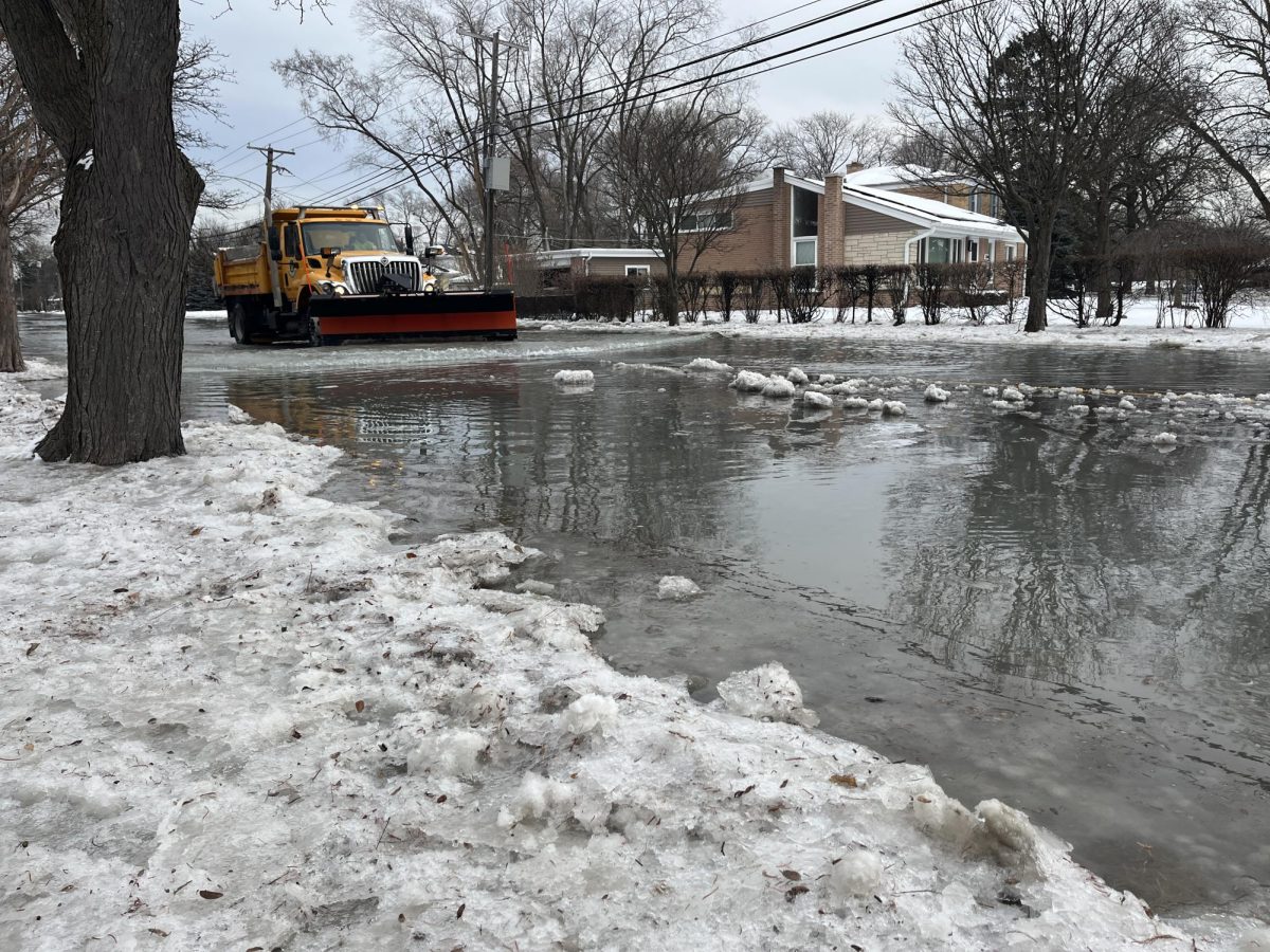 A plow travels down a flooded street near the intersection of East Prairie Road and Lyons Street, not far from the East Prairie-Emerson intersection, where a water main broke on Feb. 14. 