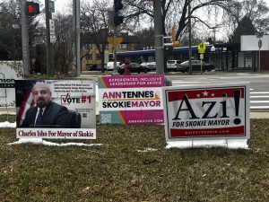 Signs promoting village mayoral candidates stand at the corner of Church Street and Kenton Avenue. 