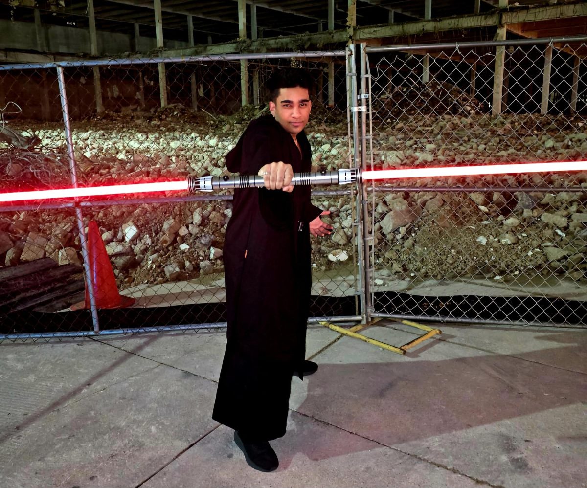 Aaqib Shareef cosplays as a sith lord for the "Star Wars" series, wielding a double-bladed lightsaber.
(Courtesy of Aaqib Shareef)